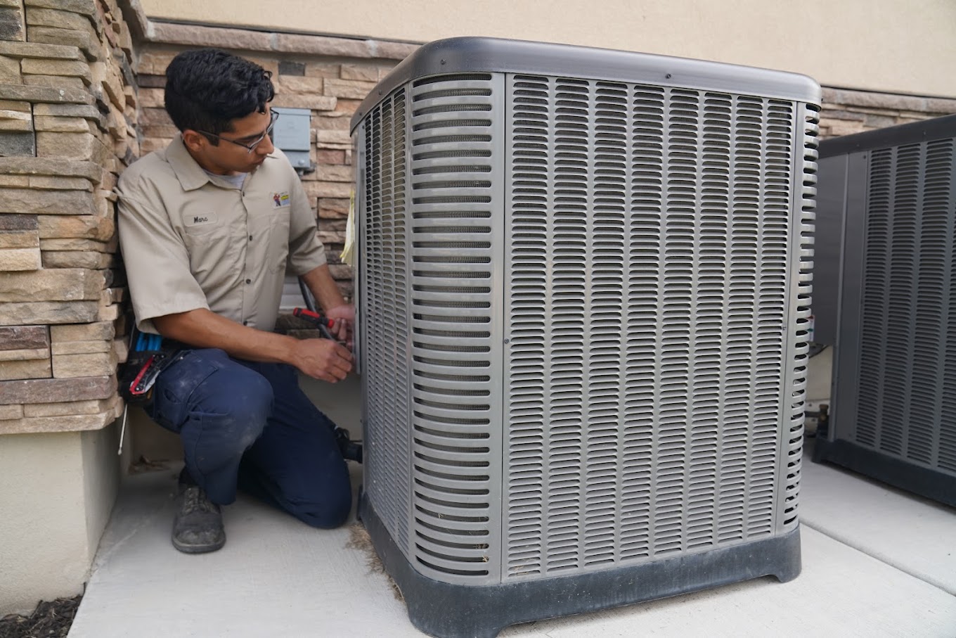 C. Woods technicians performing maintenance on an air conditioner