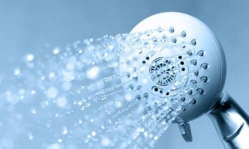 A shower head with running water installed by a plumber from C. Woods Company in Tyler, TX