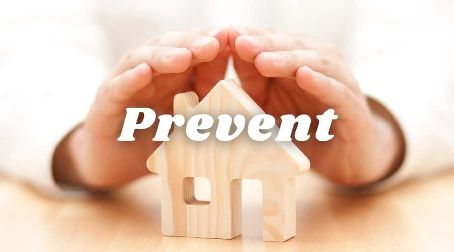 A man holding his hands over a wooden house with the word "Prevent". C. Woods Company in Tyler TX