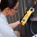 An HVAC tech from C. Woods Company in Tyler, TX performing maintenance on an AC unit