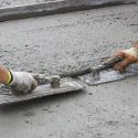 Two men smoothing fresh concrete. Call C. Woods Company for home services in Tyler TX