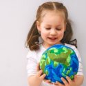A little girl with pig tails holding a ball of the earth in Tyler TX