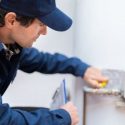 A C. Woods company plumber adjusting the temperature on a hot water tank in Tyler TX