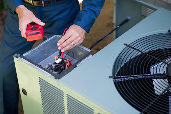 An HVAC tech performing maintenance on an AC unit in Tyler, TX