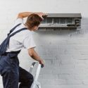 An HVAC tech performing maintenance on a ductless system C. Woods Company in Tyler, TX.