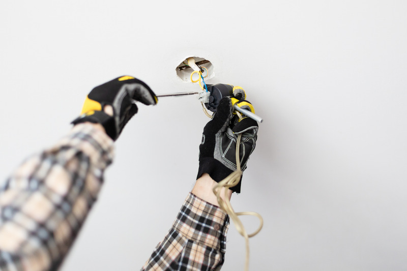 Electrician from C. Woods Company repairing a light in Tyler, TX