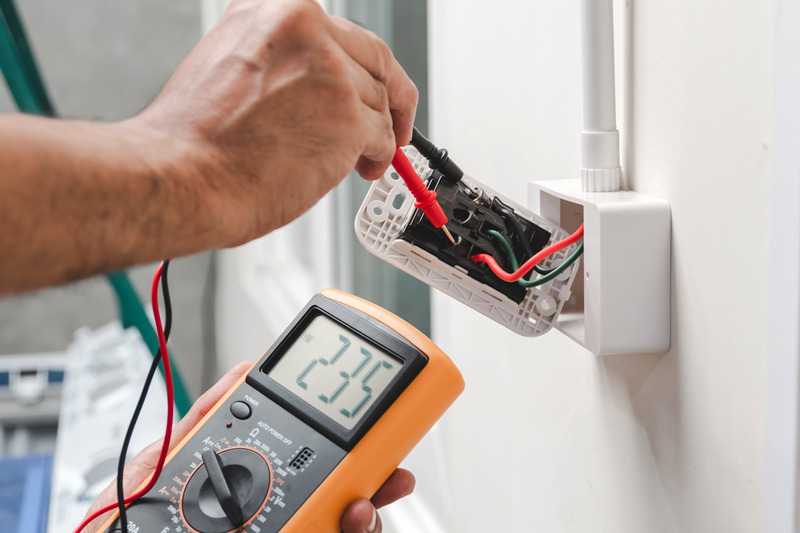 C. Woods Company electrician checking wiring in an outlet in Tyler, TX