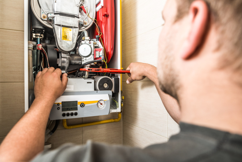 C. Woods Company HVAC technician repairing a boiler in a Tyler, TX home