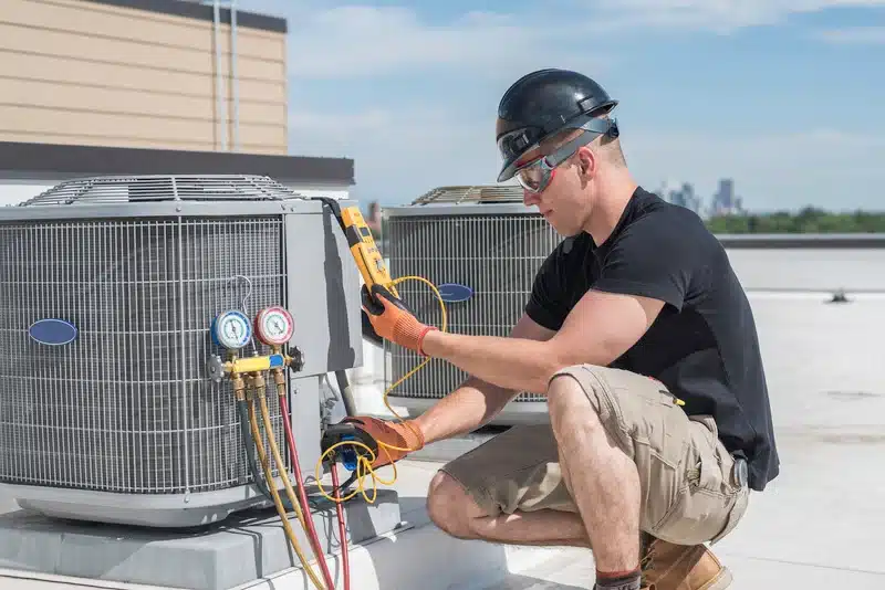 C. Woods Company employee using advanced diagnostic tools to repair AC units in Tyler, TX