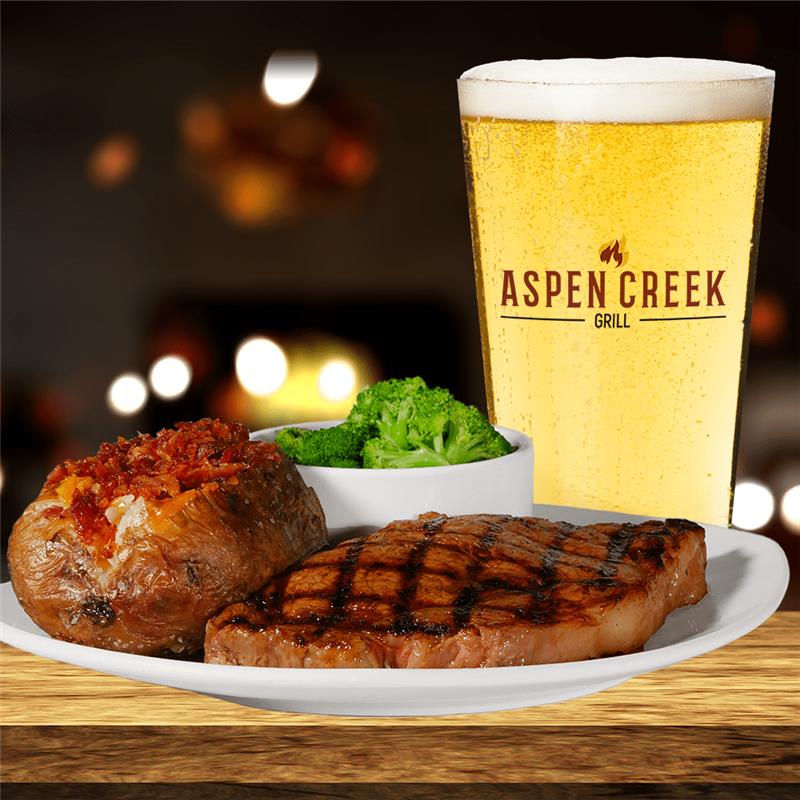 Steak and baked potato dinner with a pint glass that says Aspen Creek