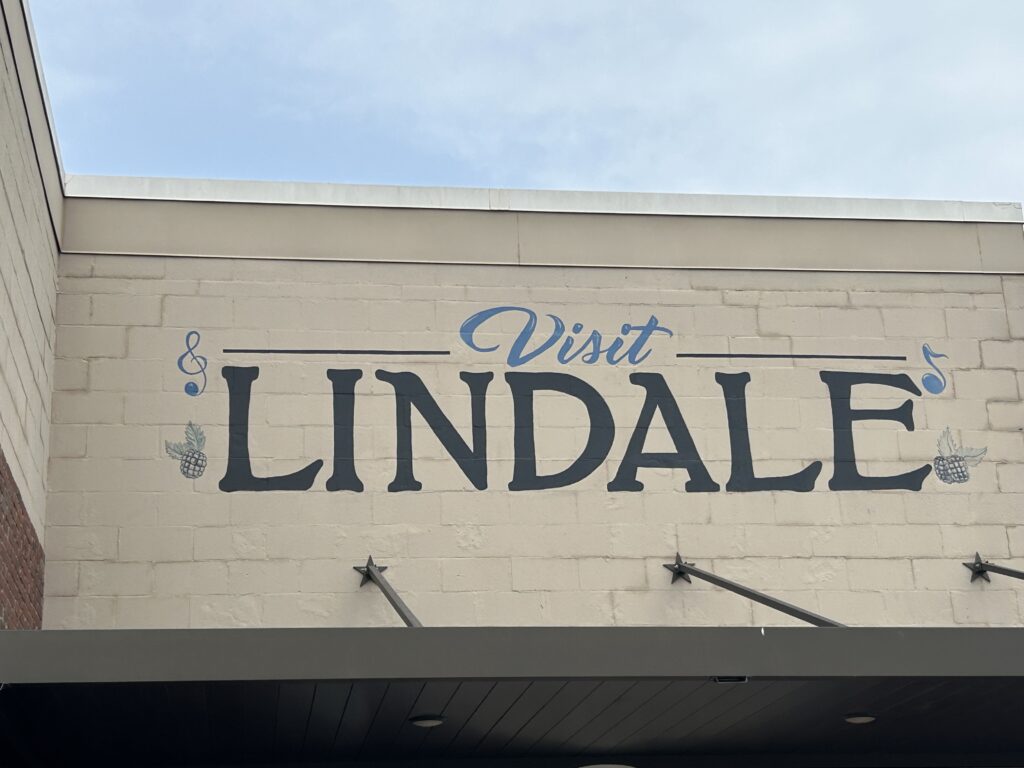 A welcome sign to Lindale, Texas, in blue writing.