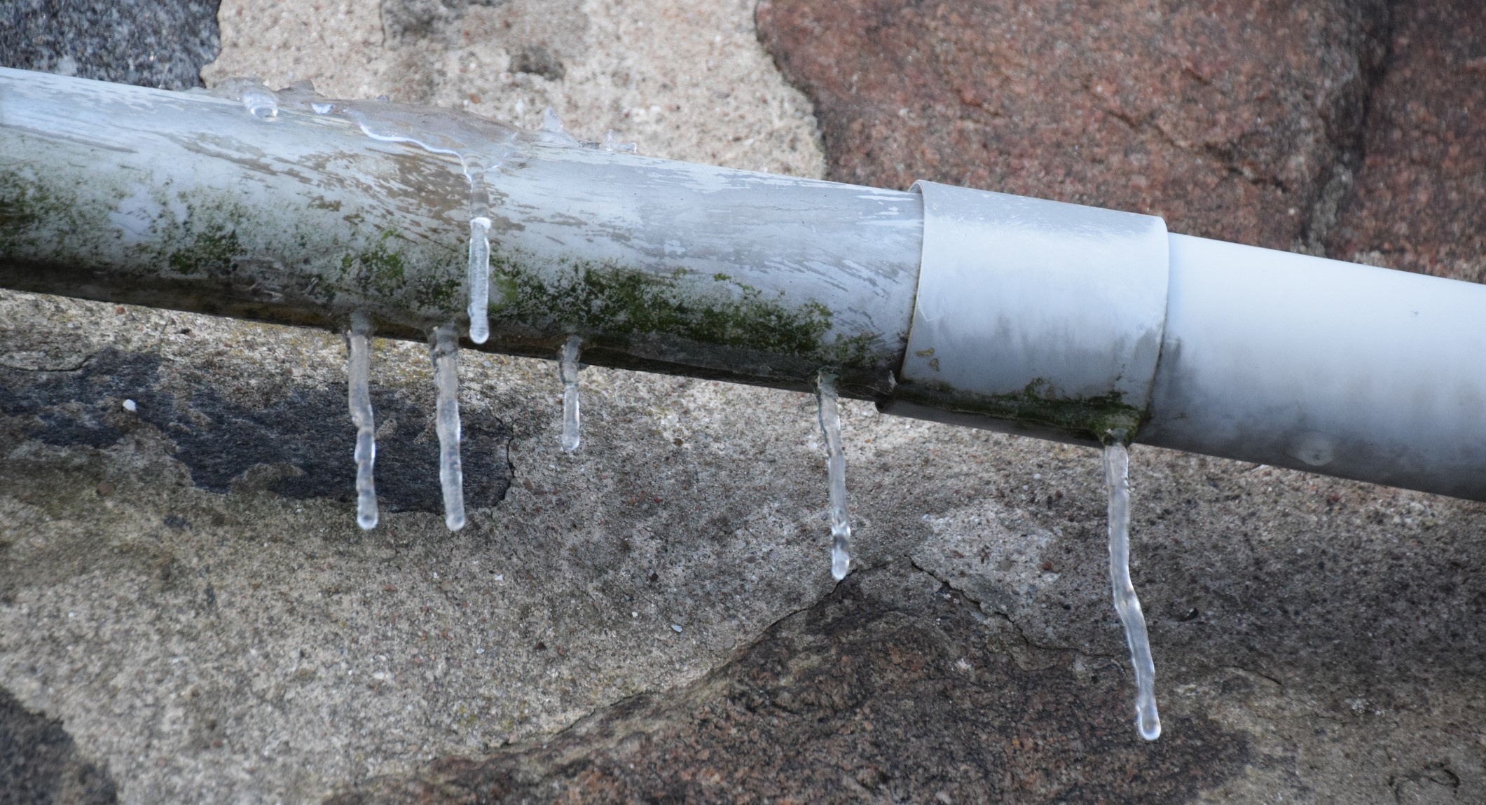 Frozen pipe with icicles dripping down